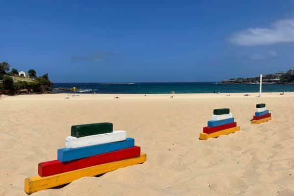 Colourful wooden stacking blocks set up on a sunny beach as part of the Mini Beach Olympics team building activities run by Pinnacle Team Events