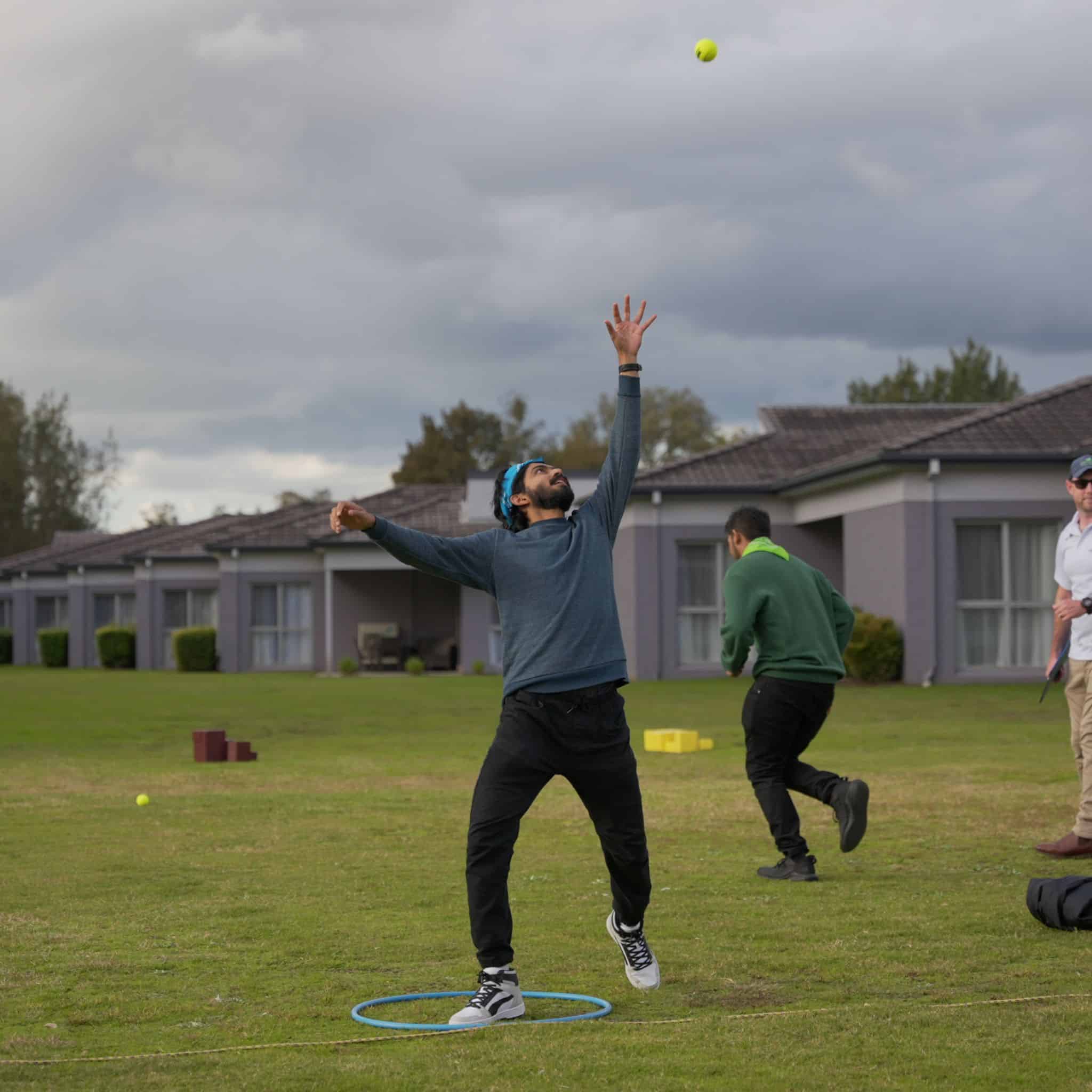 Corporate participant catching a ball during the Catapult challenge at a Ransom outdoor team building event with Pinnacle Team Events