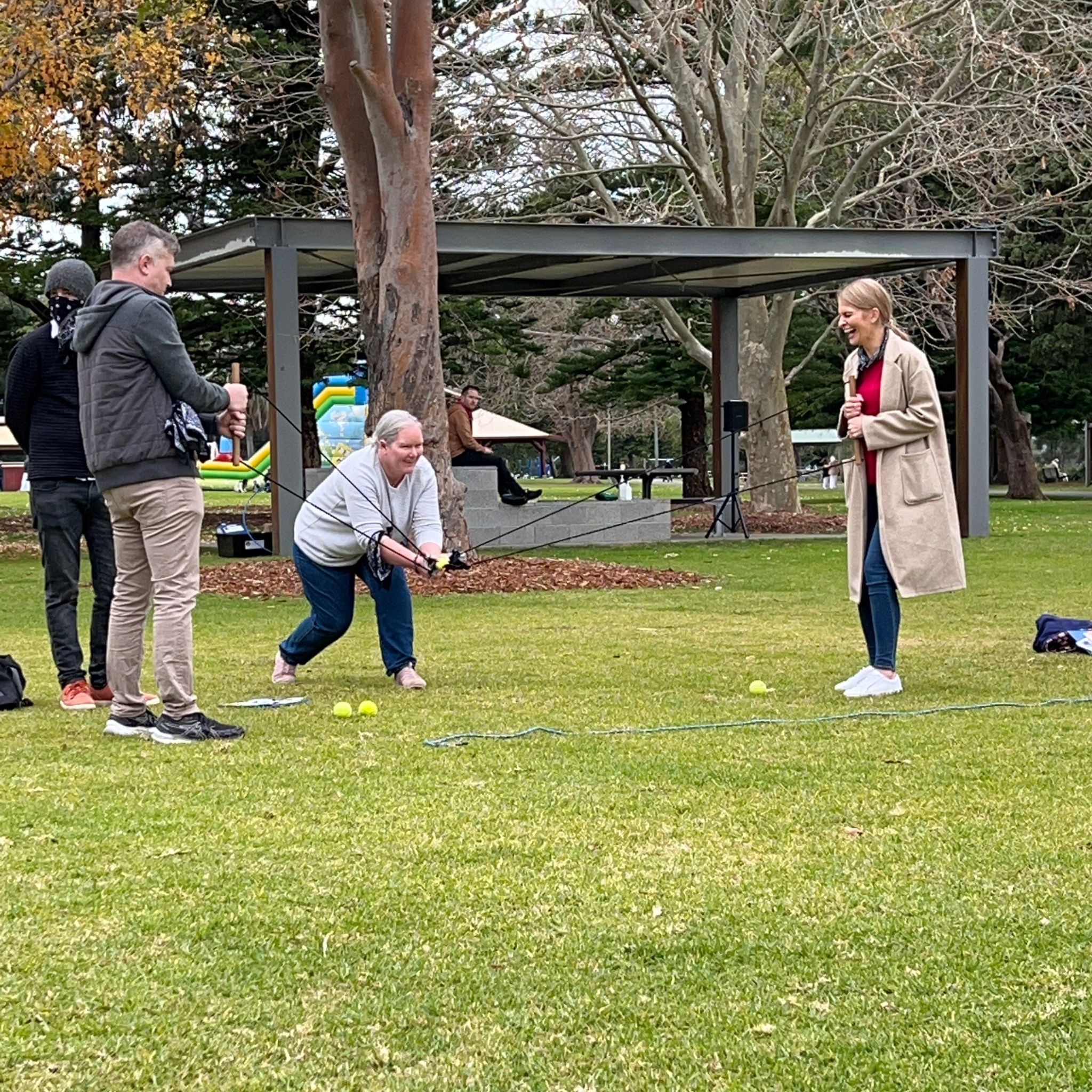 Corporate team members using a catapult to launch a ball during the Ransom outdoor team building activity facilitated by Pinnacle Team Events