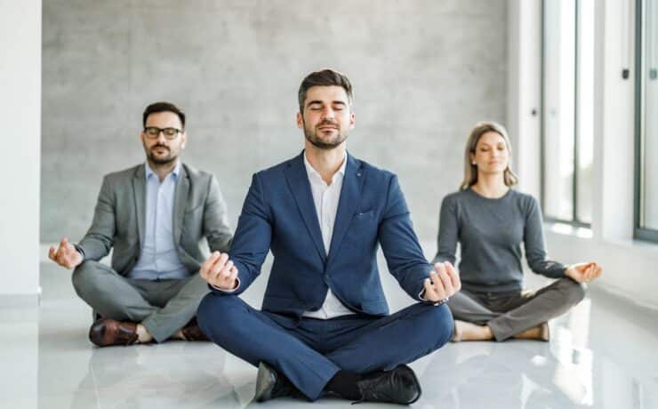 staff in suits performing yoga team building