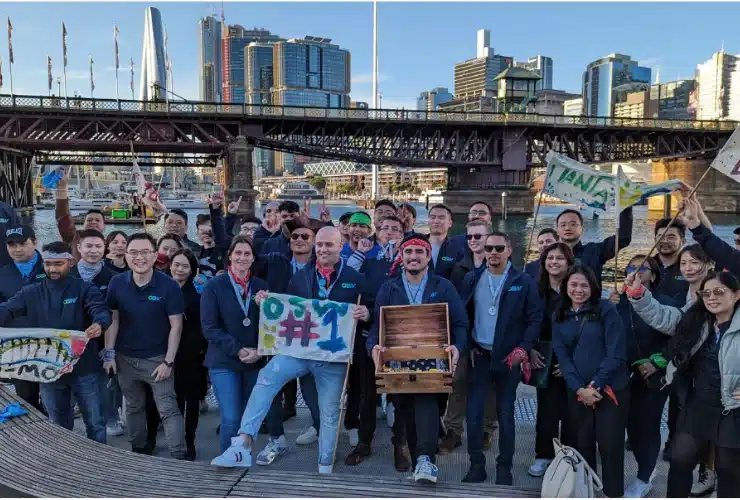 Group of people holding items related to Tresure Hunt acvitity. Such as flags, maps, and a treasure box.