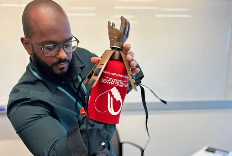 Male testing the prosthetic hand built in Helping Hands workshop