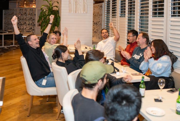 people sitting at table cheering and laughing